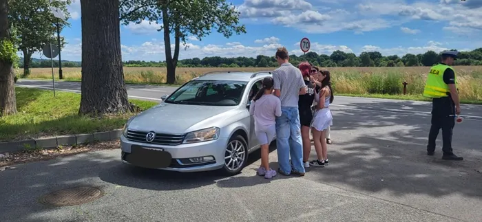 Wychowankowie Placówki Wsparcia Dziennego w dzielnicy Leszczyny wręczający gadżety profilaktyczne kierowcy