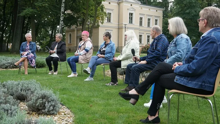 Kadr z odcinka 1 programu Seniorze, bądź bezpieczny. Na zdjęciu członkowie grupy nieformalnej Seniorzy z Zameczku, a w tle leszczyński Zameczek (źródło: Telewizja TVS)