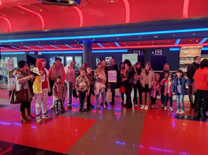Wyjazd do kina - na zdjęciu uczestnicy projektu przed wejściem do sali kinowej, w której zobaczą film "Asteriks i Obeliks: Imperium smoka"