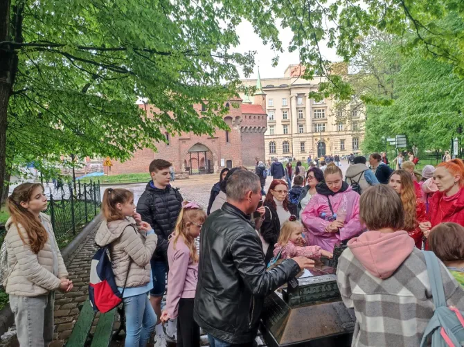 Wyjazd do Krakowa - na zdjęciu przewodnik przy jednej z makiet opowiadający uczestnikom wyjazdu historię miasta