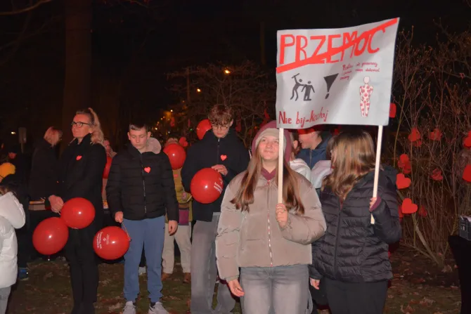 Dzieci idące w przemarszu, w rękach trzymające transparenty i czerwone balony