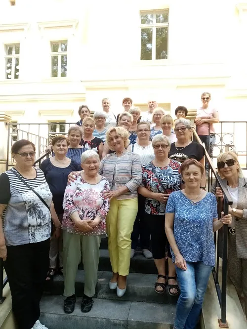 Na zdjęciu "Seniorzy z Zameczku" wraz z Walentyną Kozioł na schodach prowadzących na taras przy "Zameczku" w Leszczynach