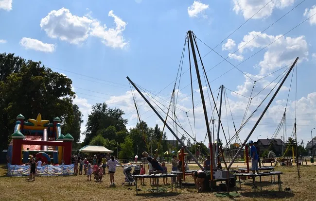 Eurobungee, czyli trampolina z linami i uczestniczy z niej korzystający. W tle dmuchaniec typu zamek (zdj. Katarzyna Mazur)