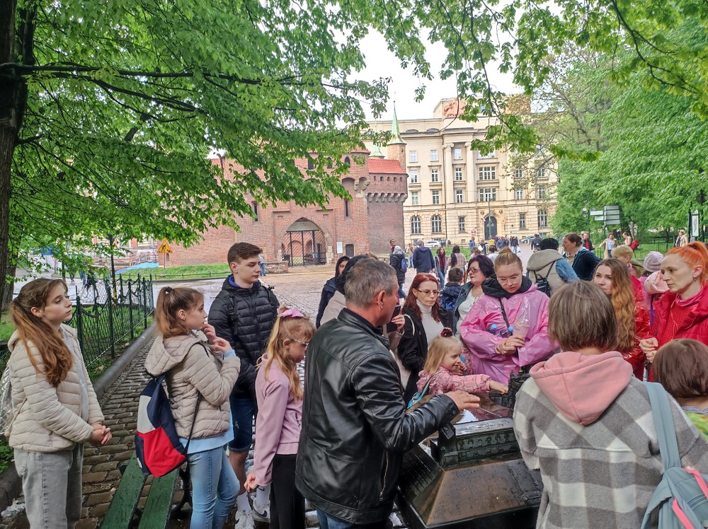 Wyjazd do Krakowa - na zdjęciu przewodnik przy jednej z makiet opowiadający uczestnikom wyjazdu historię miasta